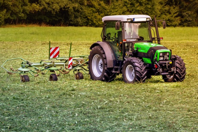 Traktor mit Mähmaschine auf Wiese